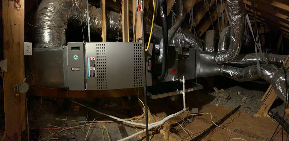 HVAC system installation in a residential attic with ductwork visible.